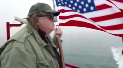 Michael Moore amb la bandera dels EUA.